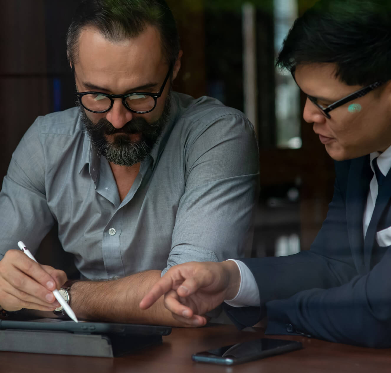 Two men looking at an ipad