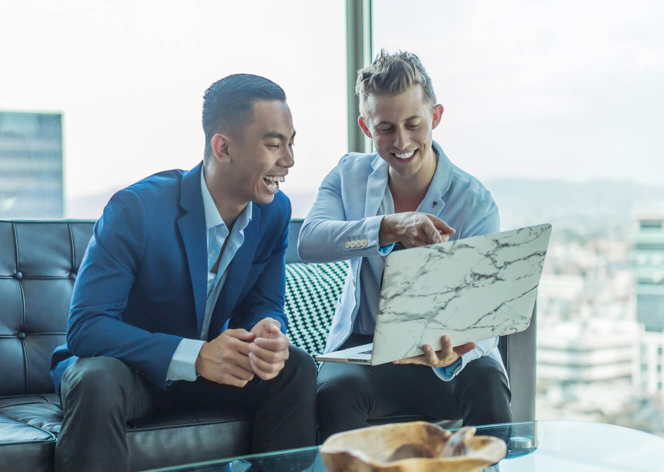 two men looking at a laptop